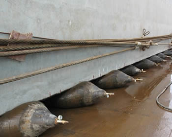 Several airbags are used to lift heavy concrete constructure