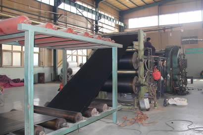 The equipment is manufacturing rubber sheet.